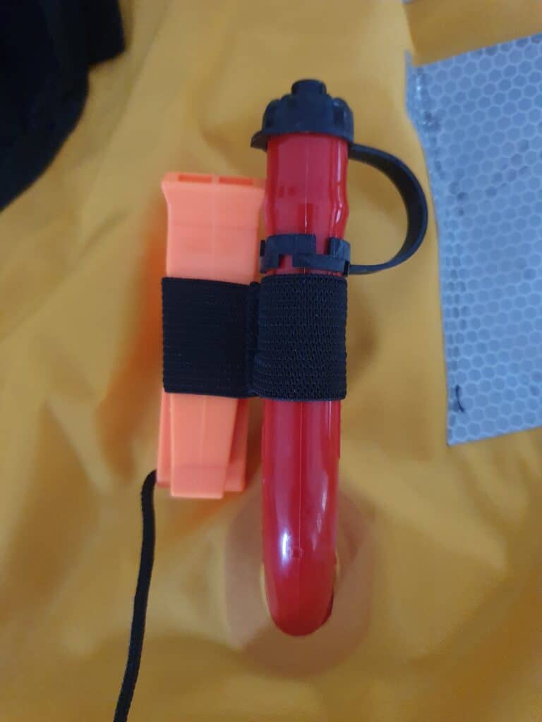 A life jacket oral inflation tube with attached whistle.
